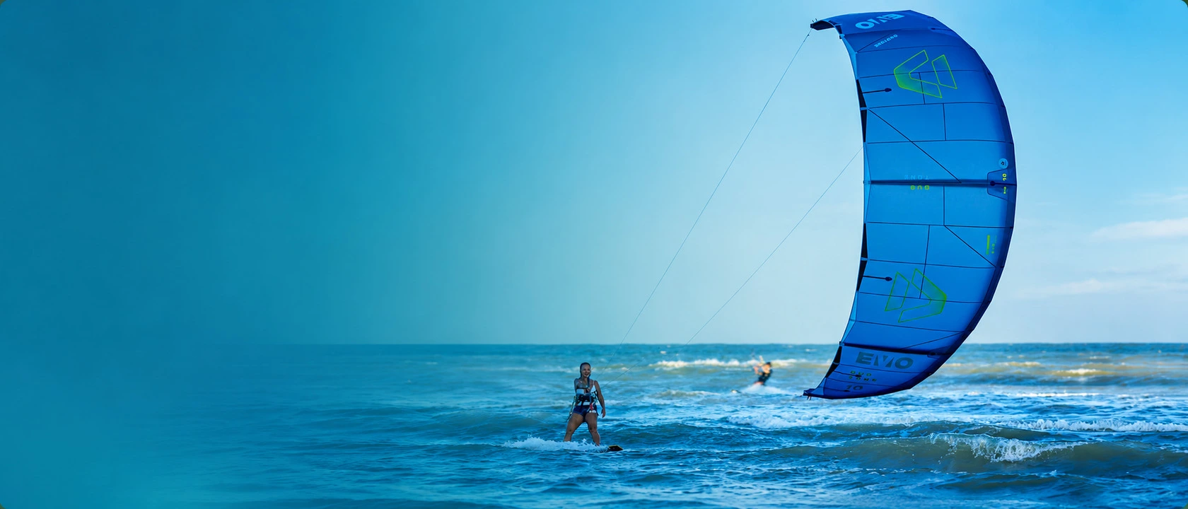 Kitesurfista navegando no mar com kite azul Duotone ao lado direito do banner.